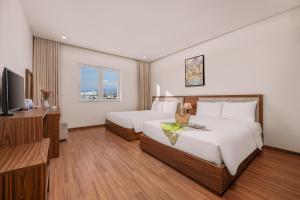 Postel nebo postele na pokoji v ubytování De Lamour Hotel Da Nang