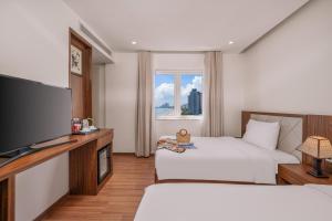 Postel nebo postele na pokoji v ubytování De Lamour Hotel Da Nang