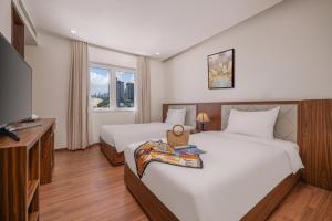 Postel nebo postele na pokoji v ubytování De Lamour Hotel Da Nang