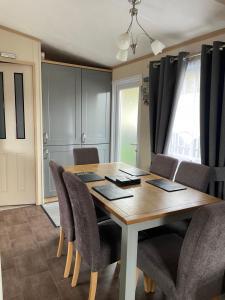 a dining room with a wooden table and chairs at Freedom Lodge-Aviemore with FREE Starlink Superfast broadband 150mbps - All bedding and towels included - Pet Free in Aviemore