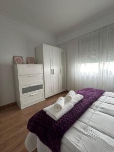 a bedroom with a large bed with towels on it at Apartamento vacacional en Ferrol in Ferrol