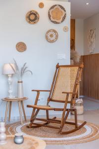 a wooden rocking chair in a living room with a table at Sunny Dream Apartment Quesada, Alicante in Rojales