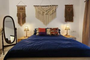 a bedroom with a blue bed and a mirror at Boho 44 in Goa