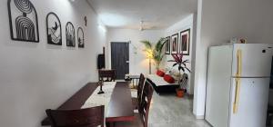 a living room with a table and a refrigerator at Boho 44 in Goa