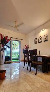 a dining room with a table and chairs and a window at Boho 44 in Goa
