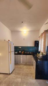 a kitchen with a white refrigerator in a room at Boho 44 in Goa