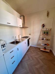 a kitchen with white cabinets and a sink and a stove at Casa Salvia in Turin