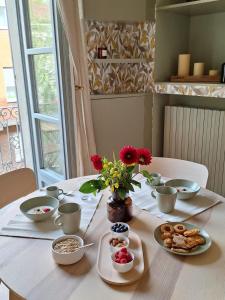 a table with breakfast foods and flowers on it at Casa Salvia in Turin +37 photos