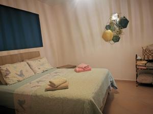 a bedroom with a bed with two towels on it at Xaido's House near airport port sea in Artemida