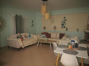 a living room with a couch and a table at Xaido's House near airport port sea in Artemida