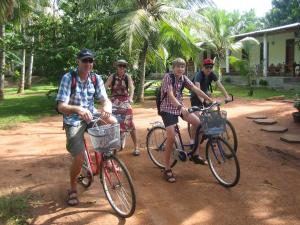 a group of people riding bikes on a dirt road at Liyana Holiday resort in Anuradhapura