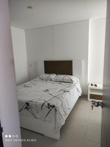 a white bedroom with a bed in a white room at Apartamento de tres habitaciones in Rodadero +17 photos