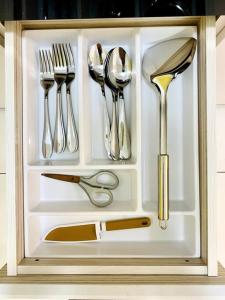 eine Schublade mit Geschirr in einem Schrank in der Unterkunft Inns Homestay 小温馨 Akademik Suite in Johor Bahru