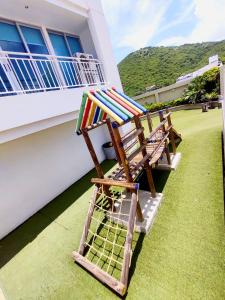 a deck chair sitting on a lawn in front of a house at Apartamento de tres habitaciones in Rodadero