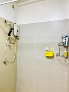 ein weißes Bad mit einer Dusche mit einem Duschkopf in der Unterkunft Inns Homestay 小温馨 Akademik Suite in Johor Bahru