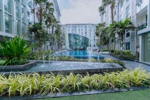 a fountain in the middle of a courtyard with buildings at City Center Residence KR in Pattaya Central