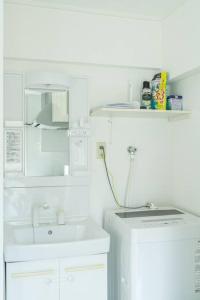 a white bathroom with a sink and a microwave at 2 min from Nakatsu Station 5person apartment in Osaka +17 photos