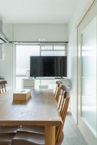 a dining room table with a flat screen tv at 2 min from Nakatsu Station 5person apartment in Osaka