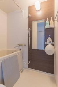 a bathroom with a shower with a mirror and a sink at 2 min from Nakatsu Station 5person apartment in Osaka