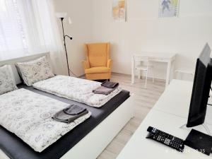 a room with a bed and a tv and a desk at Garsónka v Bratislave in Bratislava