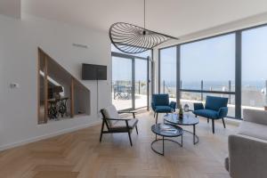 a living room with a couch and chairs and windows at AR SKOL - Magnifique duplex face à la mer in Porspoder