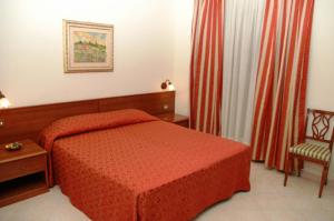 a bedroom with a red bed and a chair at Villa Verde 2 in Guidonia