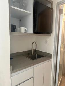 a kitchen with a sink and a flat screen tv at MAR DEL NORTE in San Juan