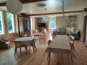 a living room with tables and chairs and a couch at Chambre Cèdre in Cadéac