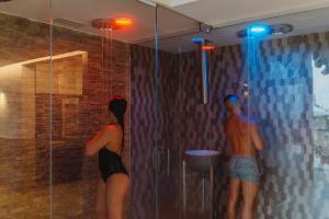 two people standing in a shower in a bathroom at Romantica Room & SPA in Ischia +5 photos