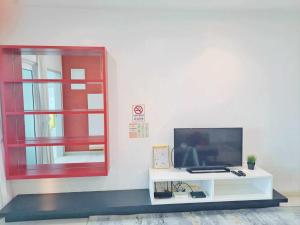 a tv sitting on a white table next to a window at Straits Garden Suites Georgetown Penang 1BRcondo in George Town
