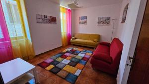 a living room with a couch and a colorful rug at A casa di Rita in Dunarobba