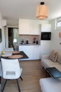 a kitchen and living room with a table and a couch at Beach House Hillasol DISHOEK in Koudekerke