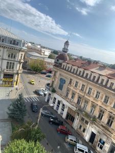 a city street with cars parked in front of a building at Geany Apartament Ultracentral in Craiova