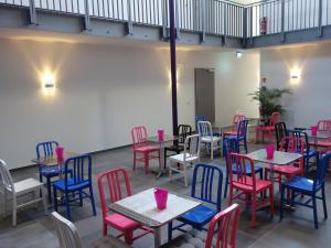 a room with tables and chairs with pink and blue chairs at Victoria Living in Jockgrim