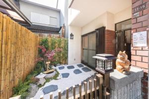 a garden with a cat sitting on a patio at House[80㎡]/Direct to Numba 7 min ~楽雅苑 Rakugaen~ in Osaka