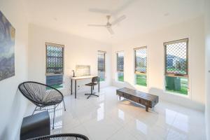 a living room with a table and chairs and windows at Belleview Home - Brand New 4 Bedroom House near Ipswich in Ripley