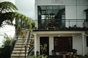 努沃勒埃利耶Lassana Villa的房屋设有楼梯和带门廊的阳台