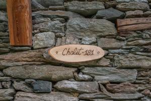 a sign on the side of a stone wall at Chalet 181 in Arvier