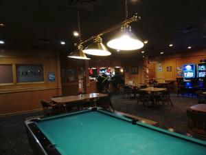 a pool table in a bar with tables and chairs at The Ritz Cafe and Motor Inn in Whitecourt