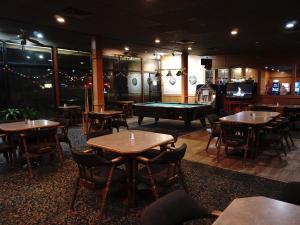 a restaurant with tables and a pool table at The Ritz Cafe and Motor Inn in Whitecourt
