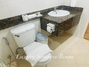 a bathroom with a white toilet and a sink at Surin Bay Inn in Surin Beach