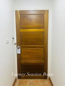 a wooden door in a room with a tile floor at Surin Bay Inn in Surin Beach