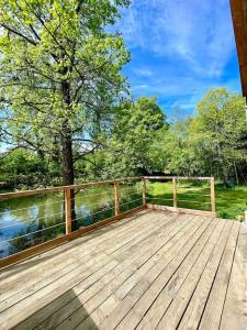 a wooden deck with a view of a body of water at Domaine de Faye in Sauvigny-les-Bois