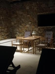 a table and chairs in a room with a stone wall at Remezzo in Ganema