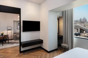 a bedroom with a bed and a tv on a wall at Sheraton Mall of the Emirates Hotel, Dubai in Dubai