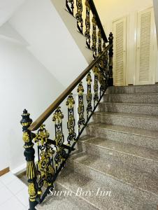 a staircase with gold and black railings in a house at Surin Bay Inn in Surin Beach