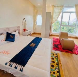 Una cama blanca grande en una habitación con una silla. en Nice Hotel Buôn Ma Thuột, en Buon Ma Thuot