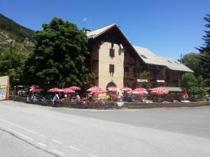 a restaurant with red umbrellas in front of a building at Le Guilazur in Château-Ville-Vieille +29 photos