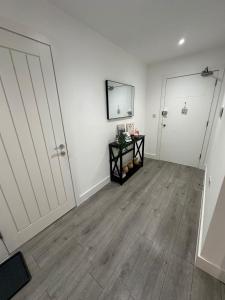 ein leeres Zimmer mit weißen Wänden und Holzböden in der Unterkunft Hemel Apartments - Hemel Haven in Hemel Hempstead