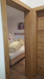 Dormitorio pequeño con cama con sábanas y almohadas blancas en Apart La Vita, en Kappl 26 fotos más